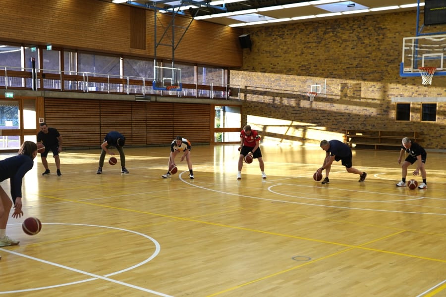 Die Spielerinnen der USC Eisvögel geben den Testo Mitarbeitern Tipps fürs perfekte Dribbeln.