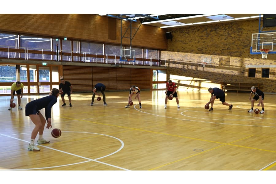 Die Spielerinnen der USC Eisvögel geben den Testo Mitarbeitern Tipps fürs perfekte Dribbeln.